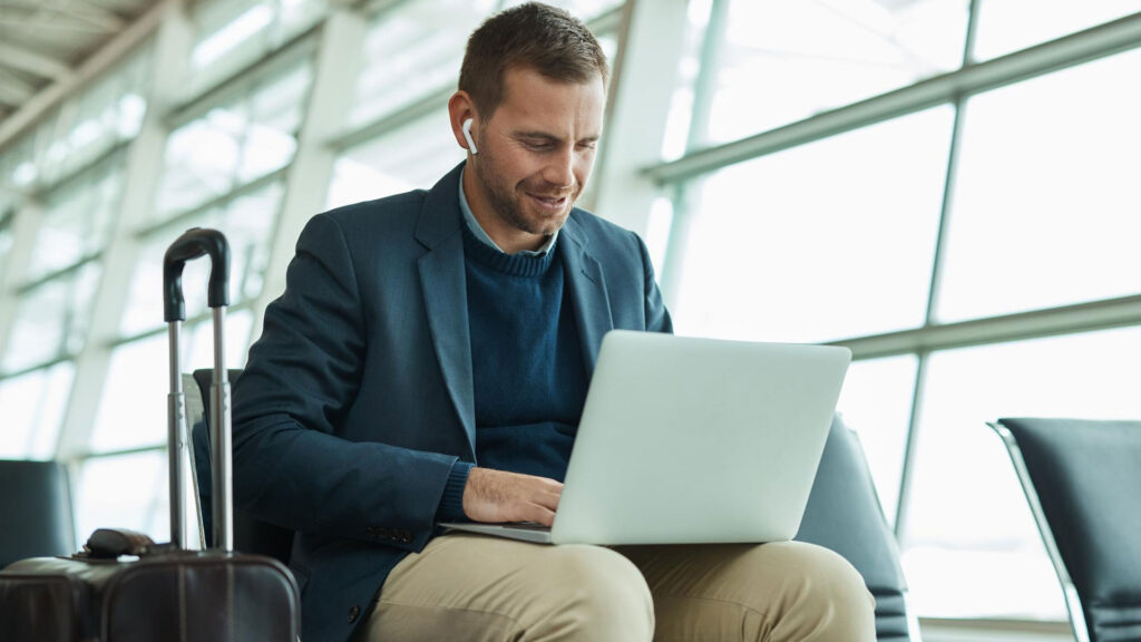 Man Working On Airport On His Laptop.